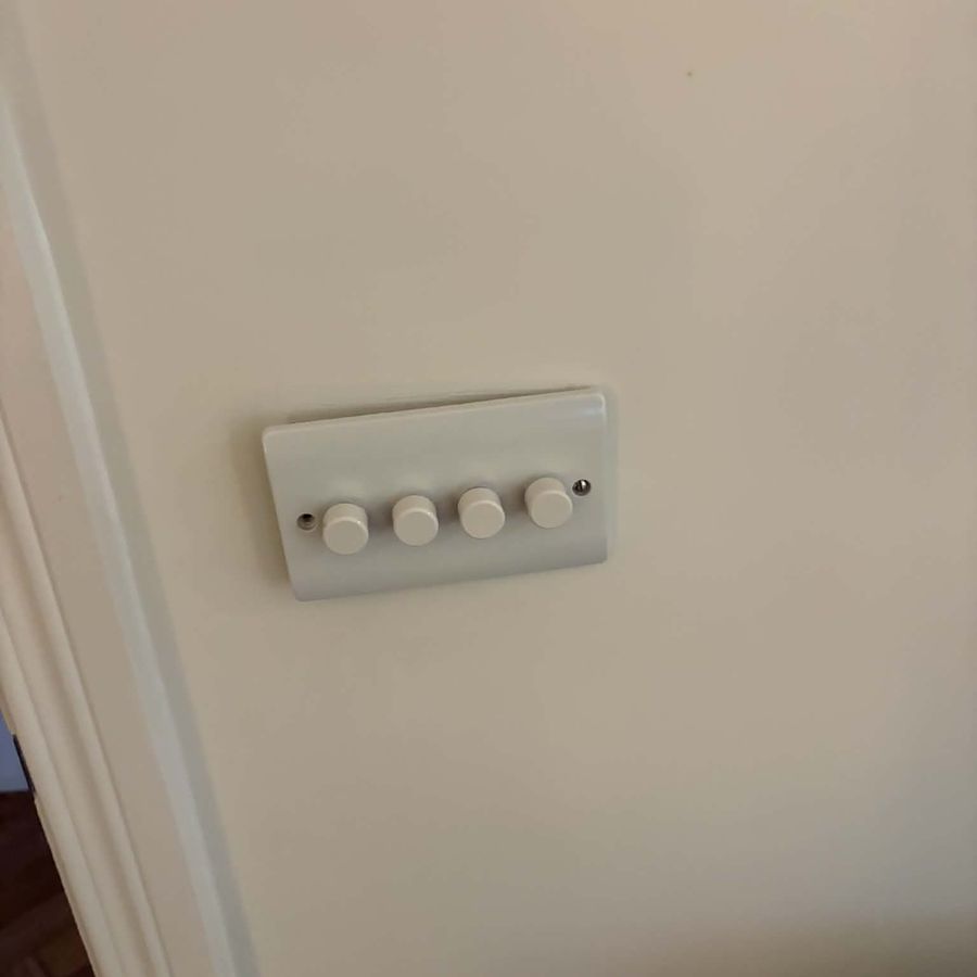 A four-gang dimmer plate fitted beside a doorway
