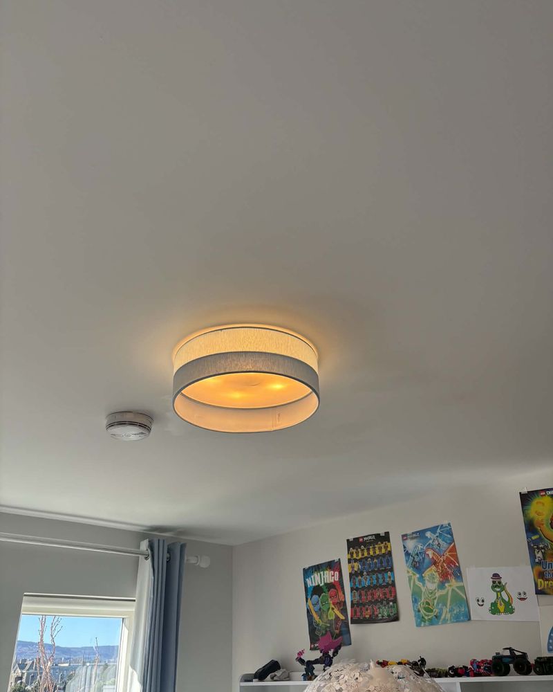 A drum pendant fitted in a bedroom, beside a smoke alarm
